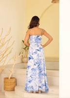 Woman wearing a blue floral dress standing in a room with a neutral color scheme.